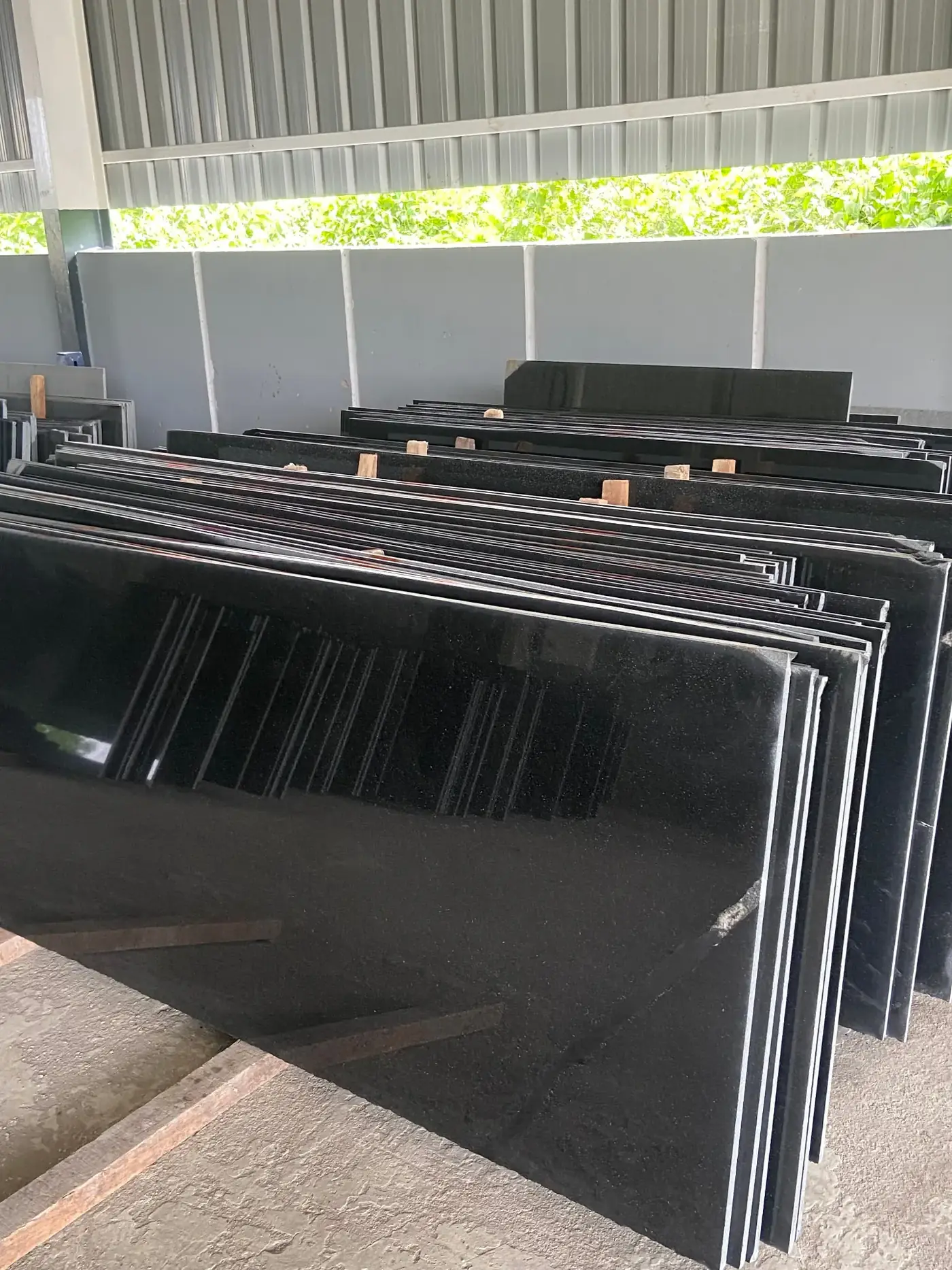 Absolute Black granite slabs stacked at the Satvaexport facility